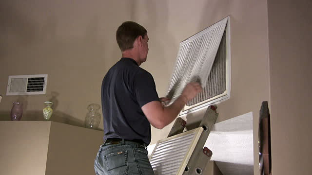 man replacing an air filter