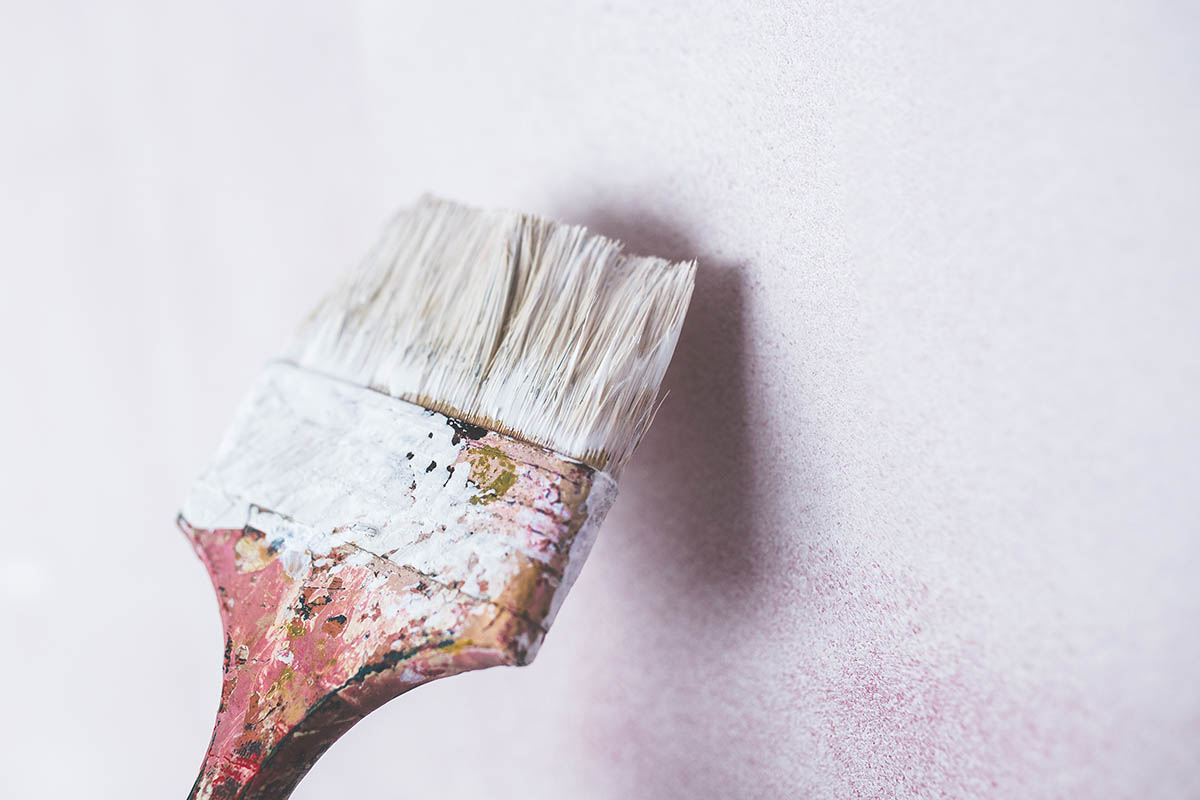 dirty paint brush painting a white wall
