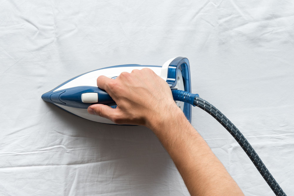 hand ironing a white sheet