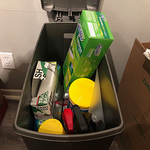 garbage can filled with cleaning supplies