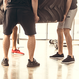 three men lifting a tire with proper lifting form