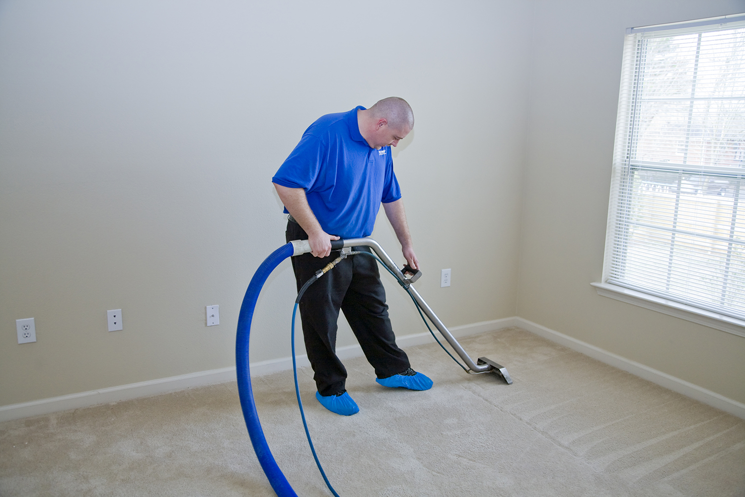 carpet cleaner cleaning a tan carpet