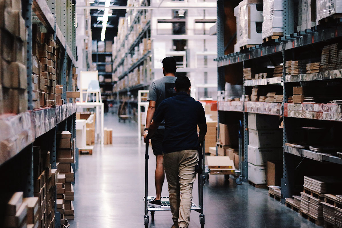 two men in the aisle of a furniture store