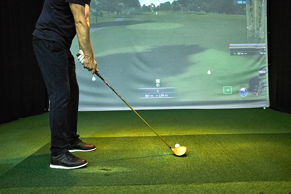 man playing on a golf simulator