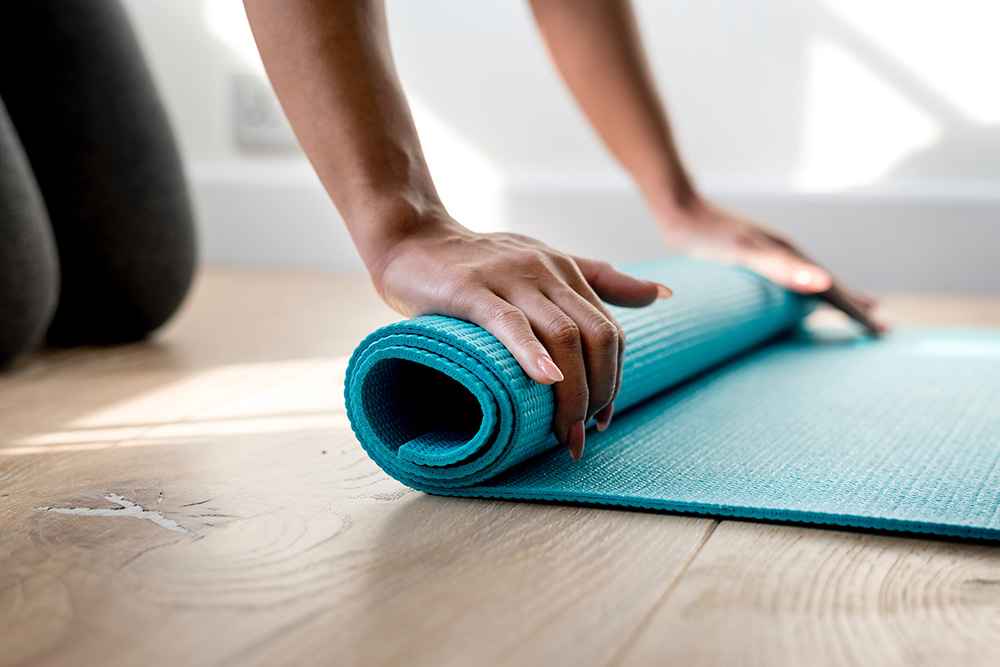 woman unrolling a yoga mat