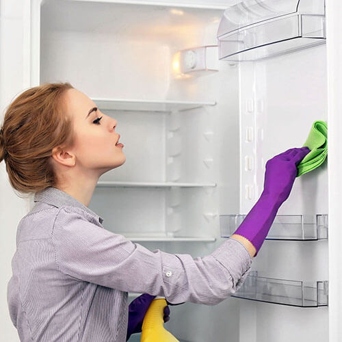 woman cleaning a refrigerator