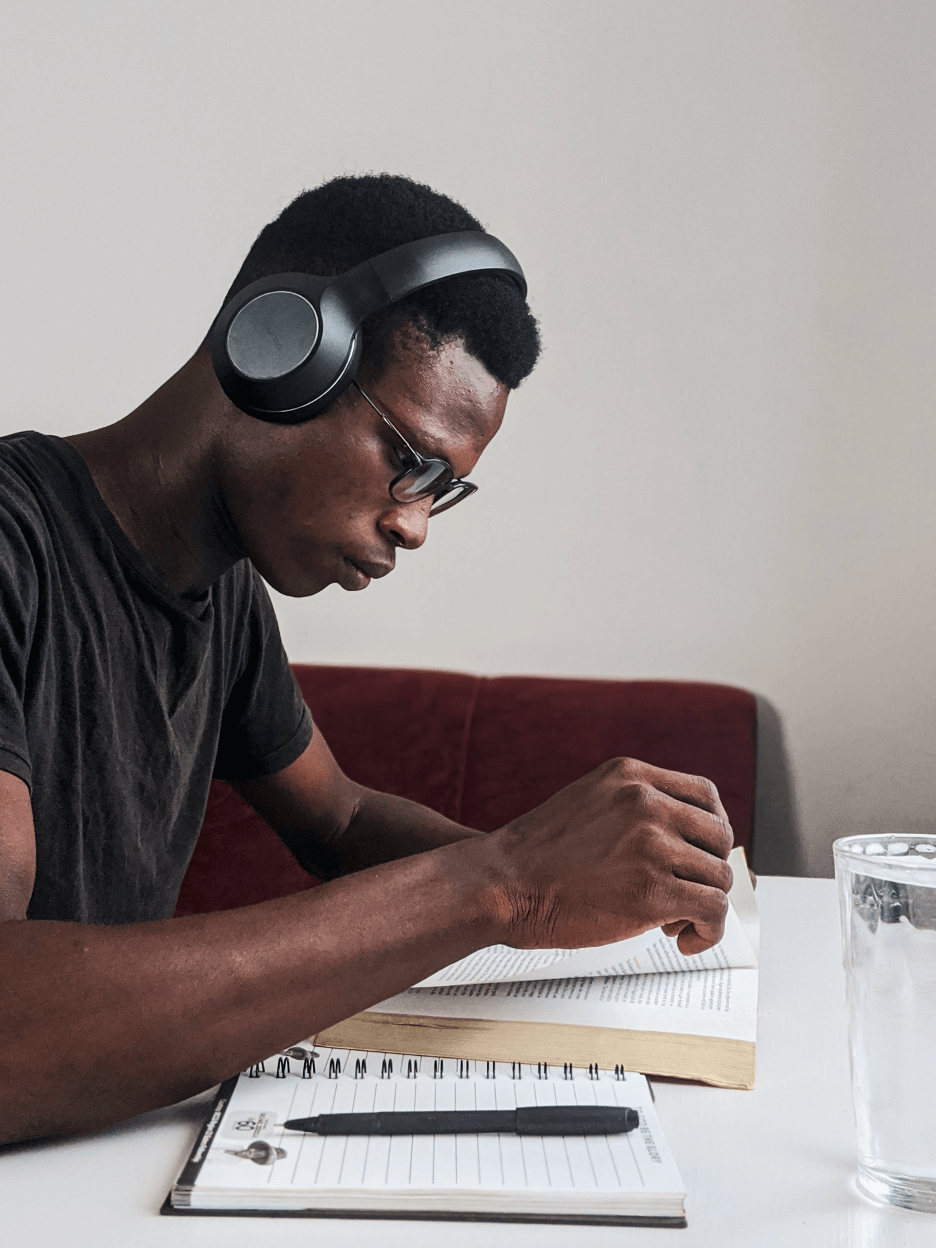 university student with headphones on reading a book