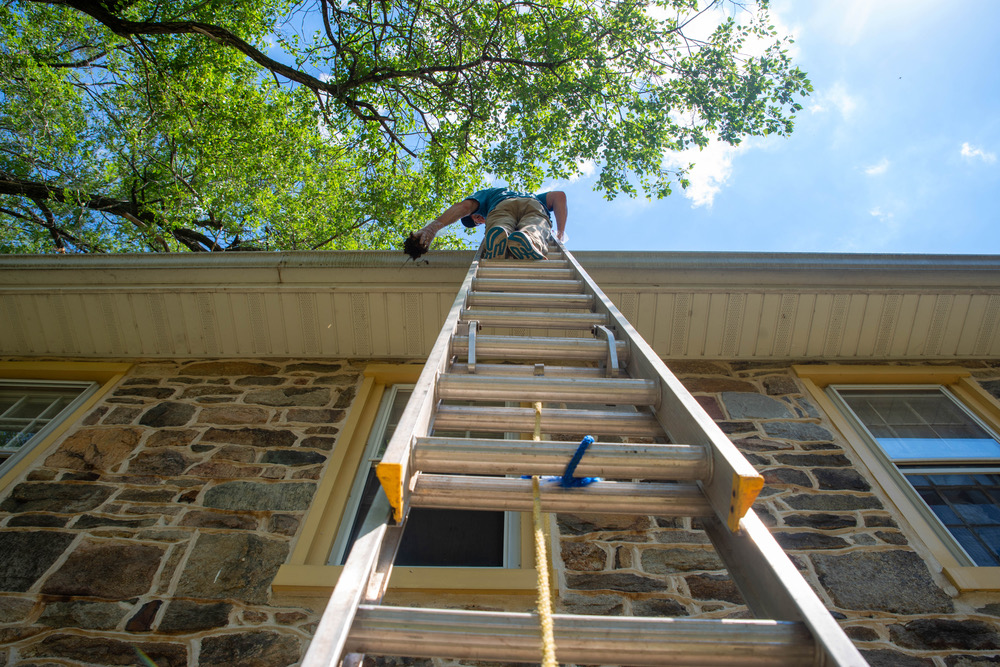 Technician cleaning debris out of a gutter